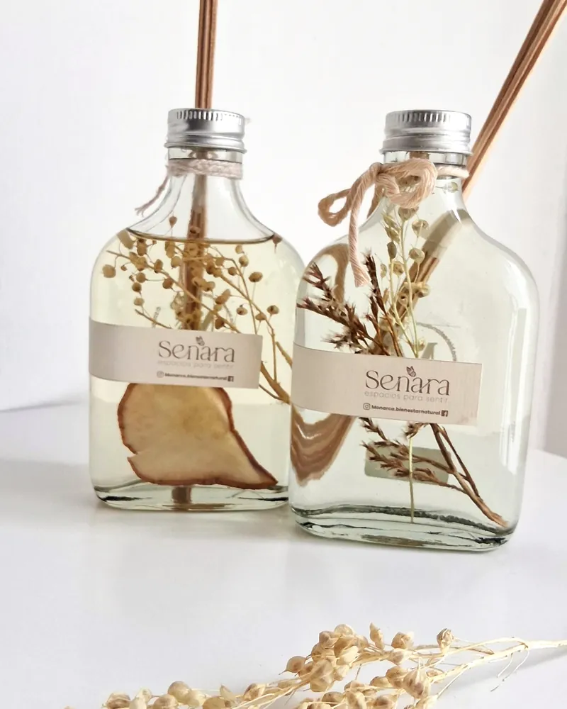 Dos difusores de varillas Senara con flores secas y pera deshidratada dentro de las botellas